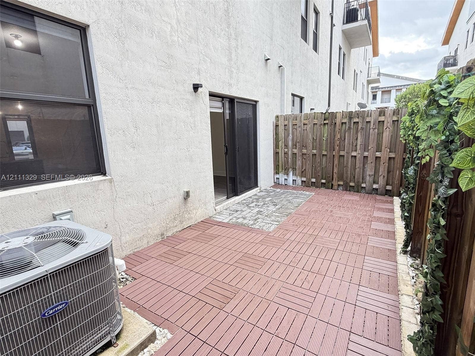 10443 NW 82nd Street, #6, Doral, Doral, FL 33178 Private patio area featuring modular wood-composite decking, paver stone section, and wood privacy fencing