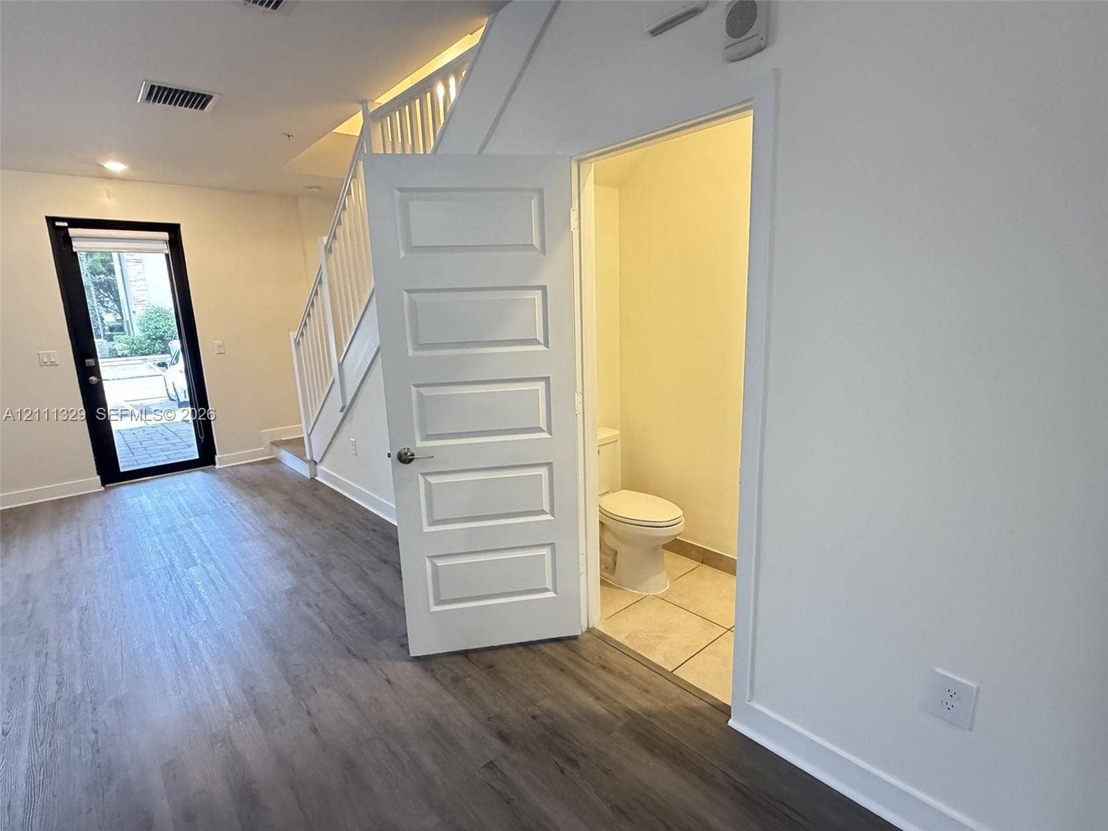 10443 NW 82nd Street, #6, Doral, Doral, FL 33178 Wood-finish flooring, white staircase railing, paneled interior door, and tile flooring