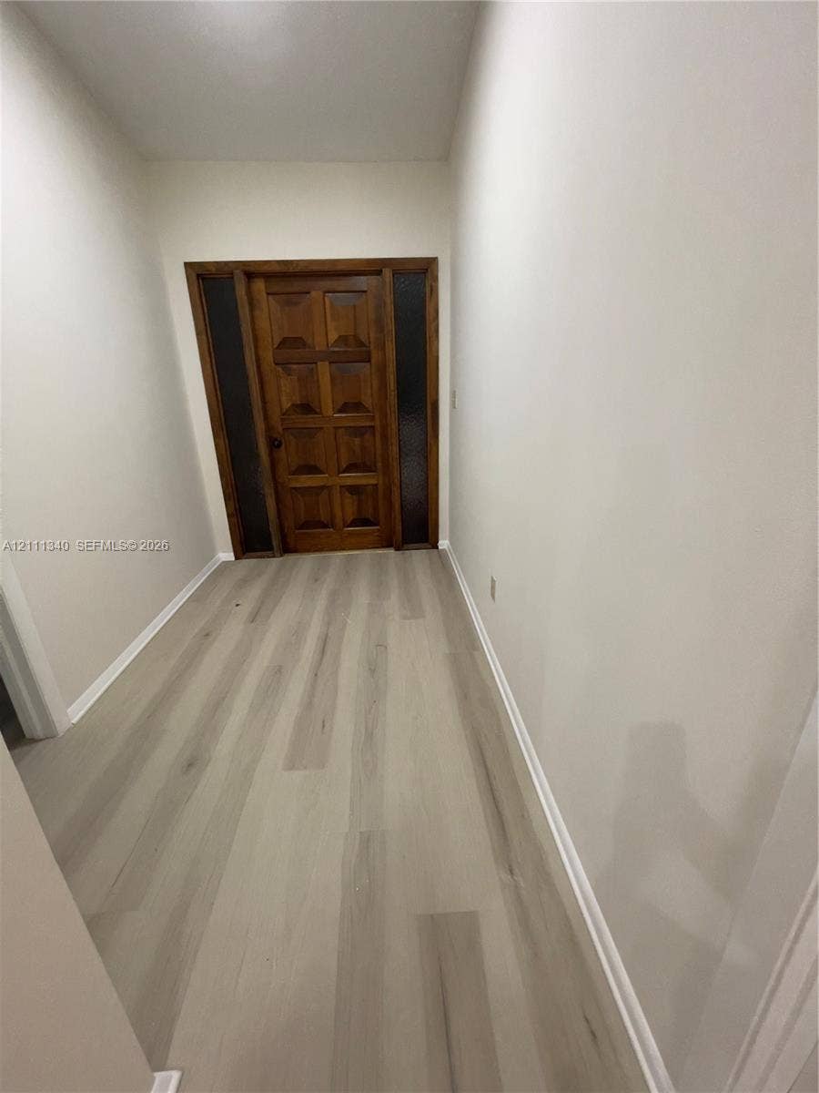 3330 SW 1st Street, Deerfield Beach, Deerfield Beach, FL 33442 Solid wood-finish front door with symmetrical glass side panels and neutral-toned wood-finish flooring