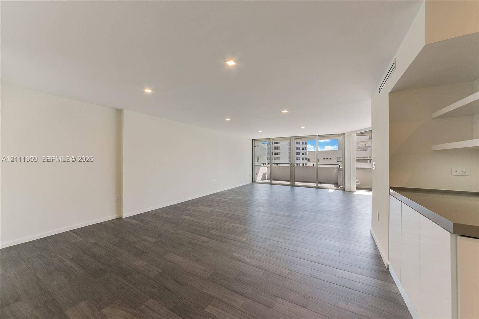 11 Island Avenue, #908, Miami Beach, Miami Beach, FL 33139 Open-concept interior featuring wood-finish flooring, recessed lighting, floor-to-ceiling glass sliding doors, private balcony, and built-in cabinetry with stone-finish countertops