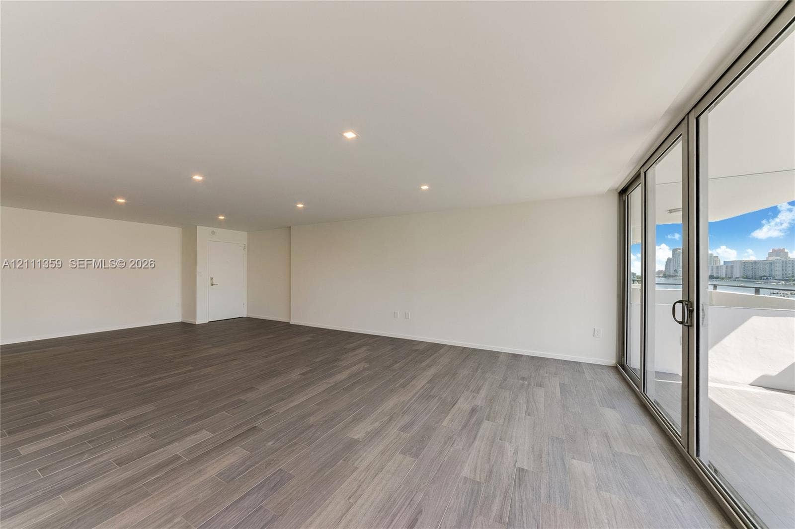 11 Island Avenue, #908, Miami Beach, Miami Beach, FL 33139 Open-concept living space featuring wood-finish flooring, recessed ceiling lighting, and floor-to-ceiling glass sliding doors leading to an outdoor balcony