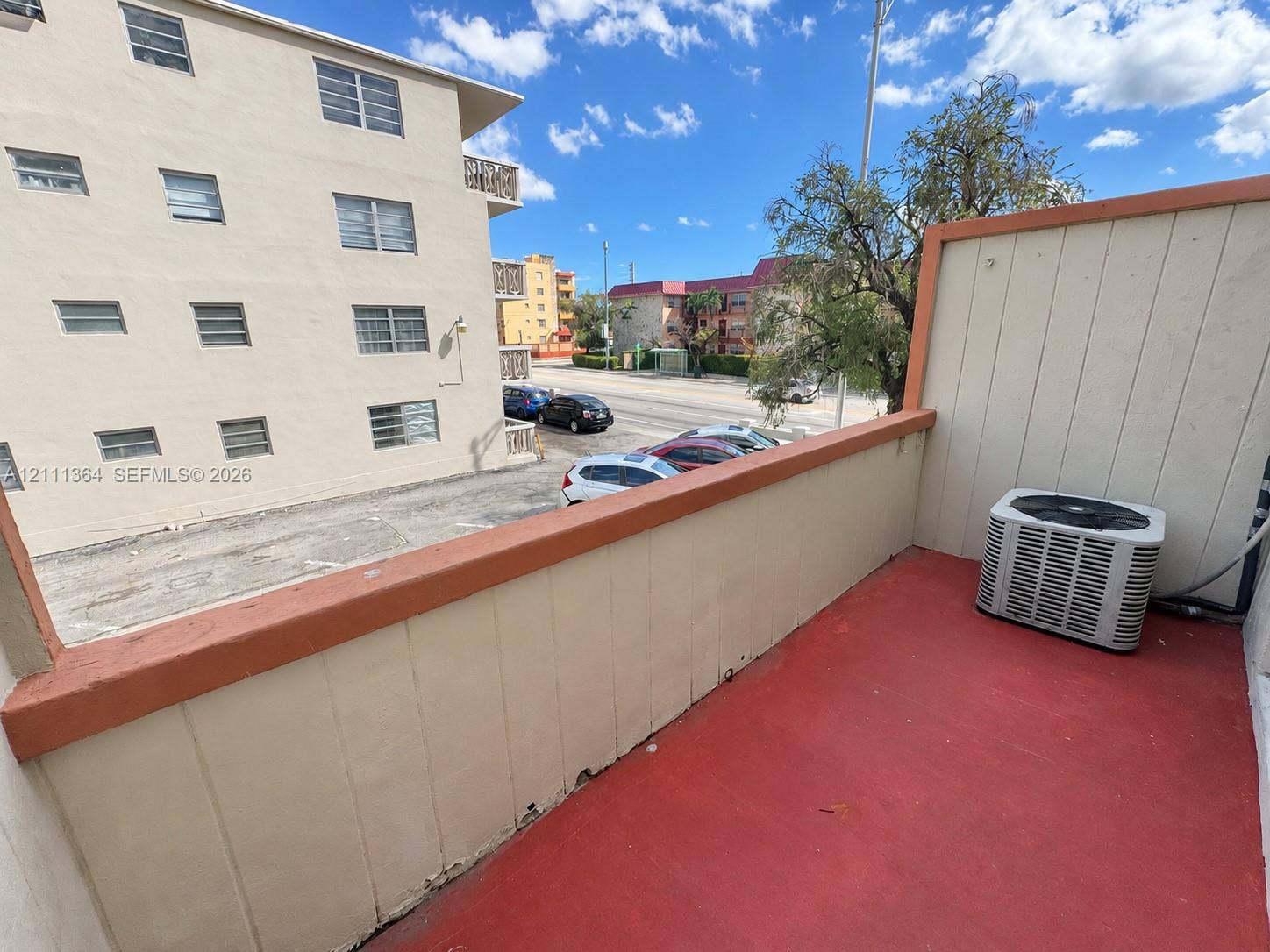 Private balcony with painted concrete flooring, capped railing, and an exterior HVAC unit