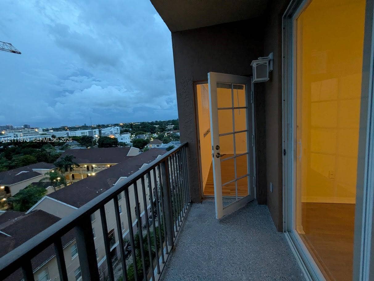 1801 N Flagler Drive, #912, West Palm Beach, West Palm Beach, FL 33401 Covered balcony featuring a metal railing, concrete flooring, exterior wall-mounted light fixture, and glass-paned door entry