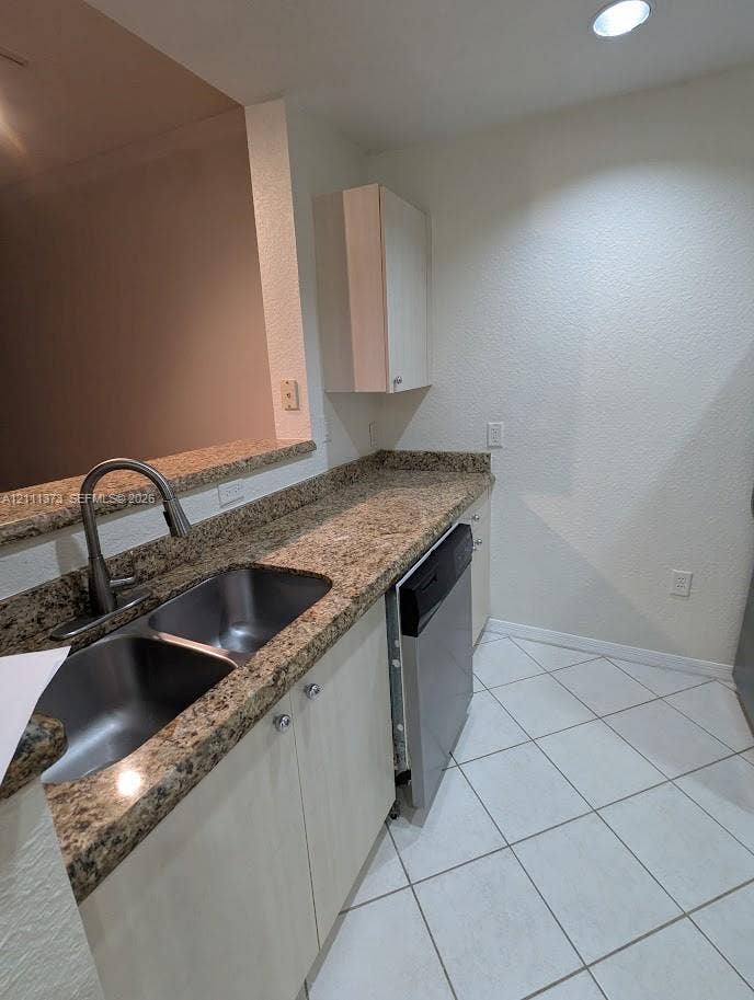 1801 N Flagler Drive, #912, West Palm Beach, West Palm Beach, FL 33401 Kitchen featuring stone-finish countertops, stainless steel double-basin undermount sink with a gooseneck faucet, built-in dishwasher, light-finish cabinetry, and tiled flooring