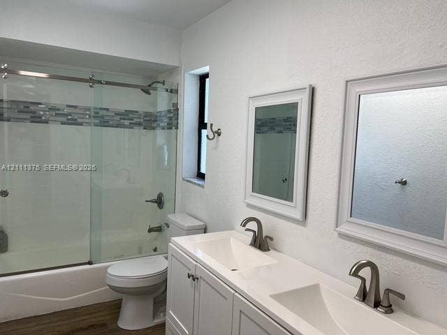 Double vanity featuring white cabinetry, a solid surface countertop with dual integrated sinks, and brushed nickel hardware