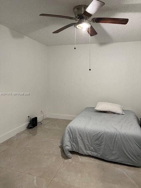 Large-format tile flooring paired with a multi-blade ceiling fan featuring integrated overhead lighting