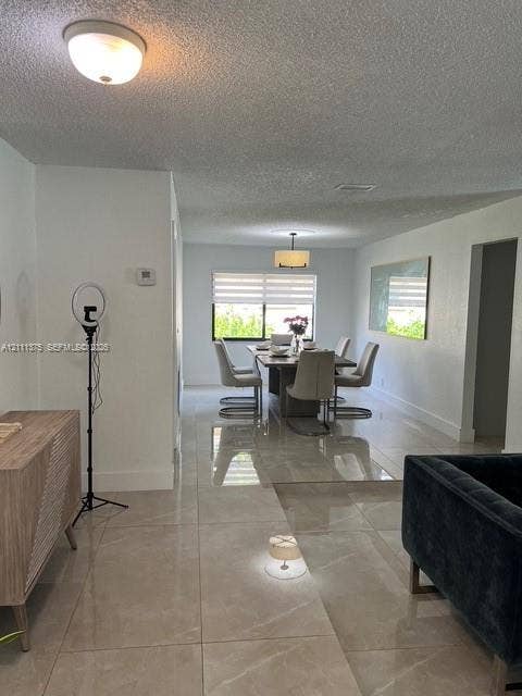 Large-format tile flooring, drum pendant lighting, flush-mount ceiling fixture, and dual-layered window shades