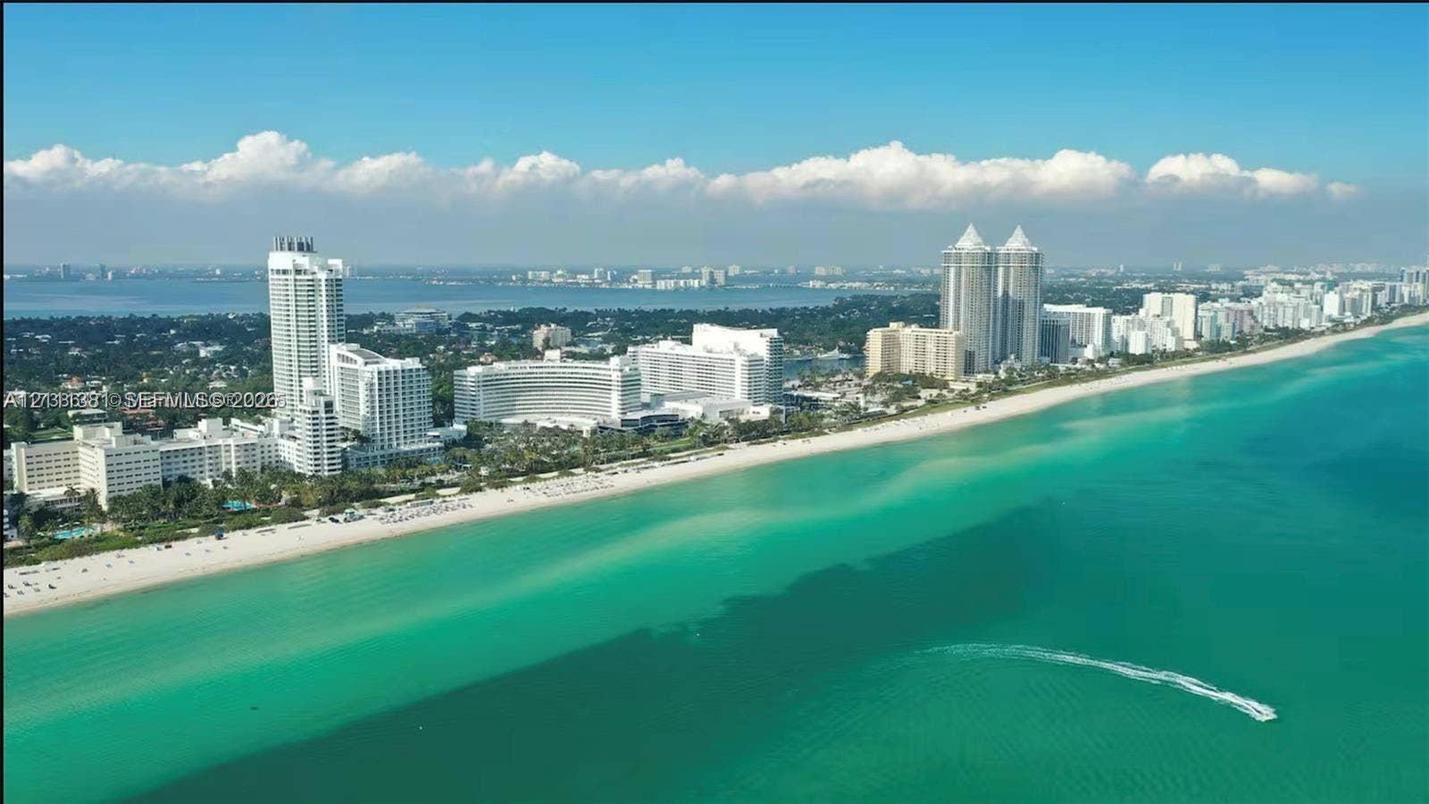 3710 Collins Avenue, #N-206, Miami Beach, FL 33140 Aerial perspective of an expansive coastline featuring turquoise water, a sandy beach, and high-rise developments