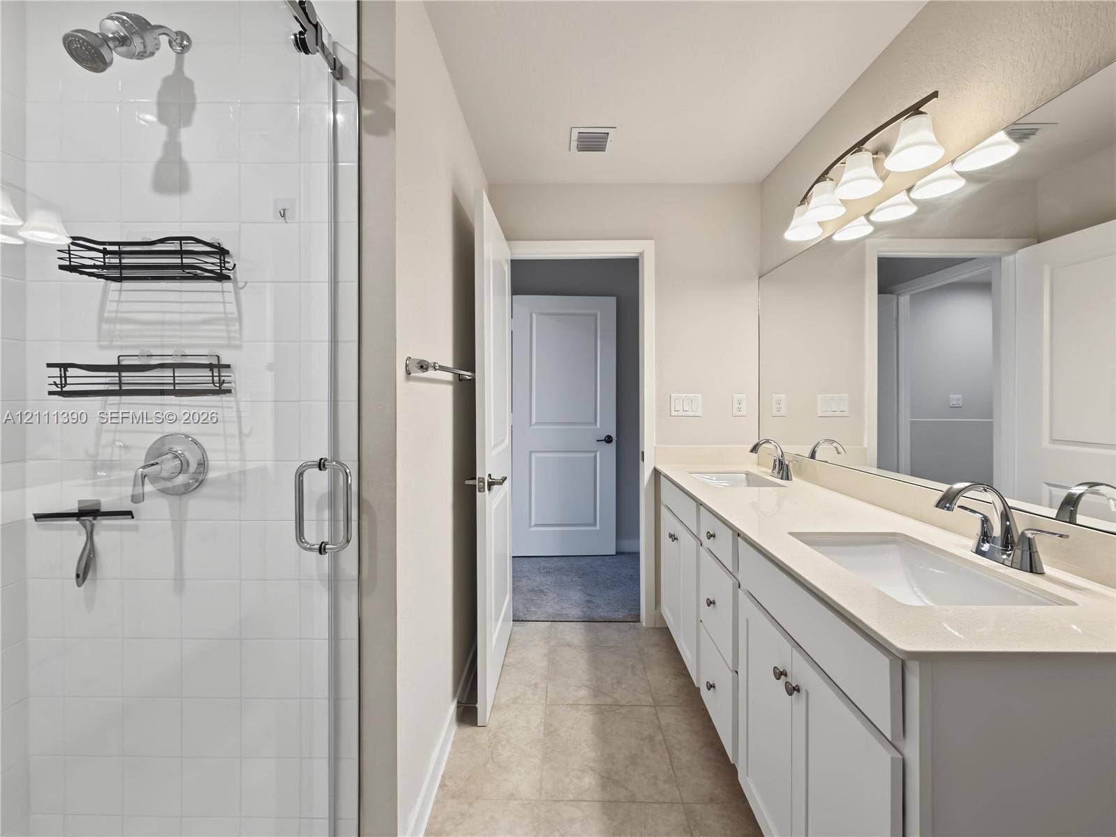 1074 NW 6th Terrace, Florida City, Florida City, FL 33034 Double vanity featuring a light-toned countertop, rectangular undermount sinks, chrome fixtures, and a multi-bulb vanity light