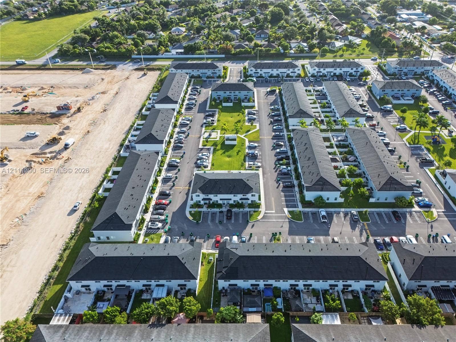 1074 NW 6th Terrace, Florida City, Florida City, FL 33034 Aerial perspective of multi-family community featuring uniform shingled rooflines, central green space, paved parking areas, and partitioned private outdoor patio sections