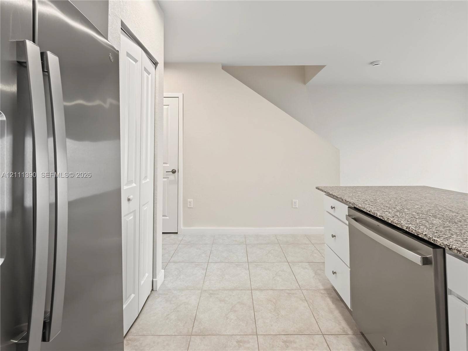1074 NW 6th Terrace, Florida City, Florida City, FL 33034 Stainless steel refrigerator, built-in dishwasher with stone-finish countertop, white shaker-style cabinetry, and ceramic tile flooring
