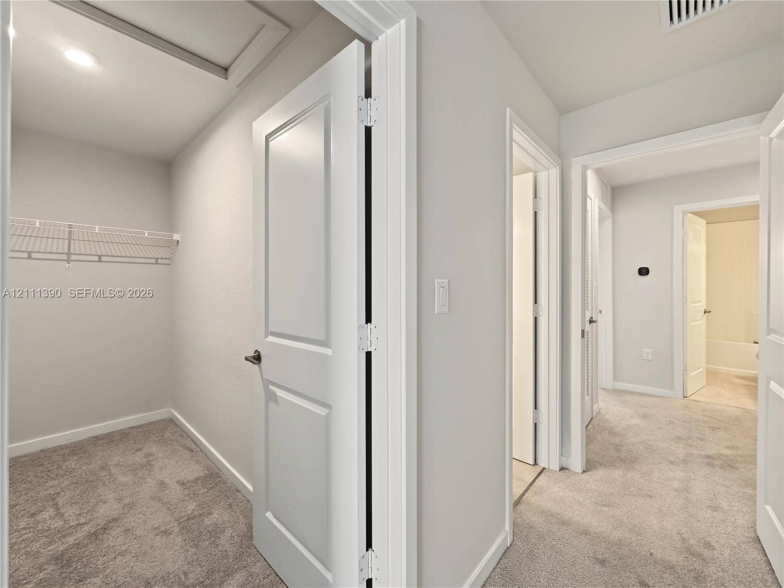 1074 NW 6th Terrace, Florida City, Florida City, FL 33034 Interior space featuring neutral-toned carpeting, two-panel interior doors, and a built-in wire shelving system
