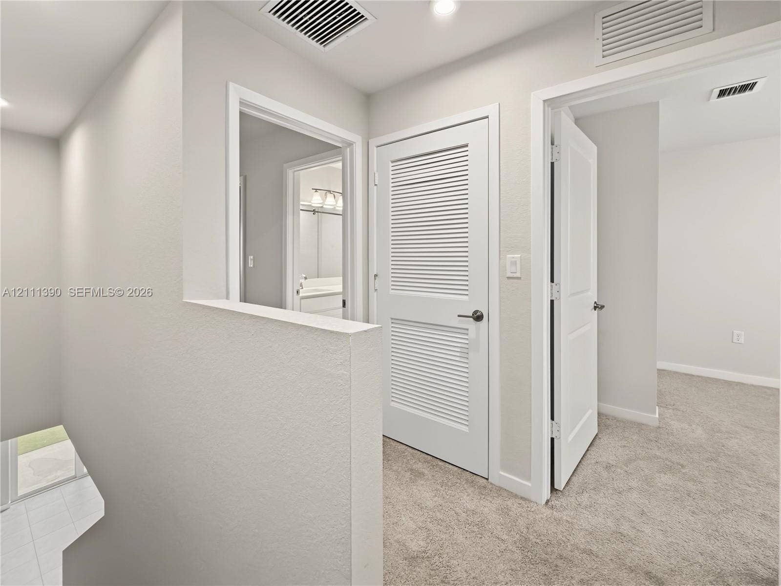 1074 NW 6th Terrace, Florida City, Florida City, FL 33034 Neutral-toned interior featuring wall-to-wall carpeting, white paneled interior doors, and a louvered closet door