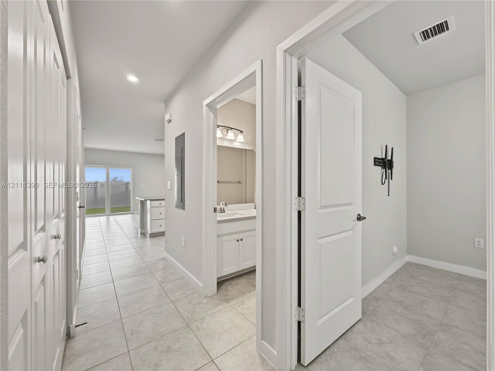 1074 NW 6th Terrace, Florida City, Florida City, FL 33034 Interior hallway featuring large-format tile flooring, white panel doors, and neutral wall tones