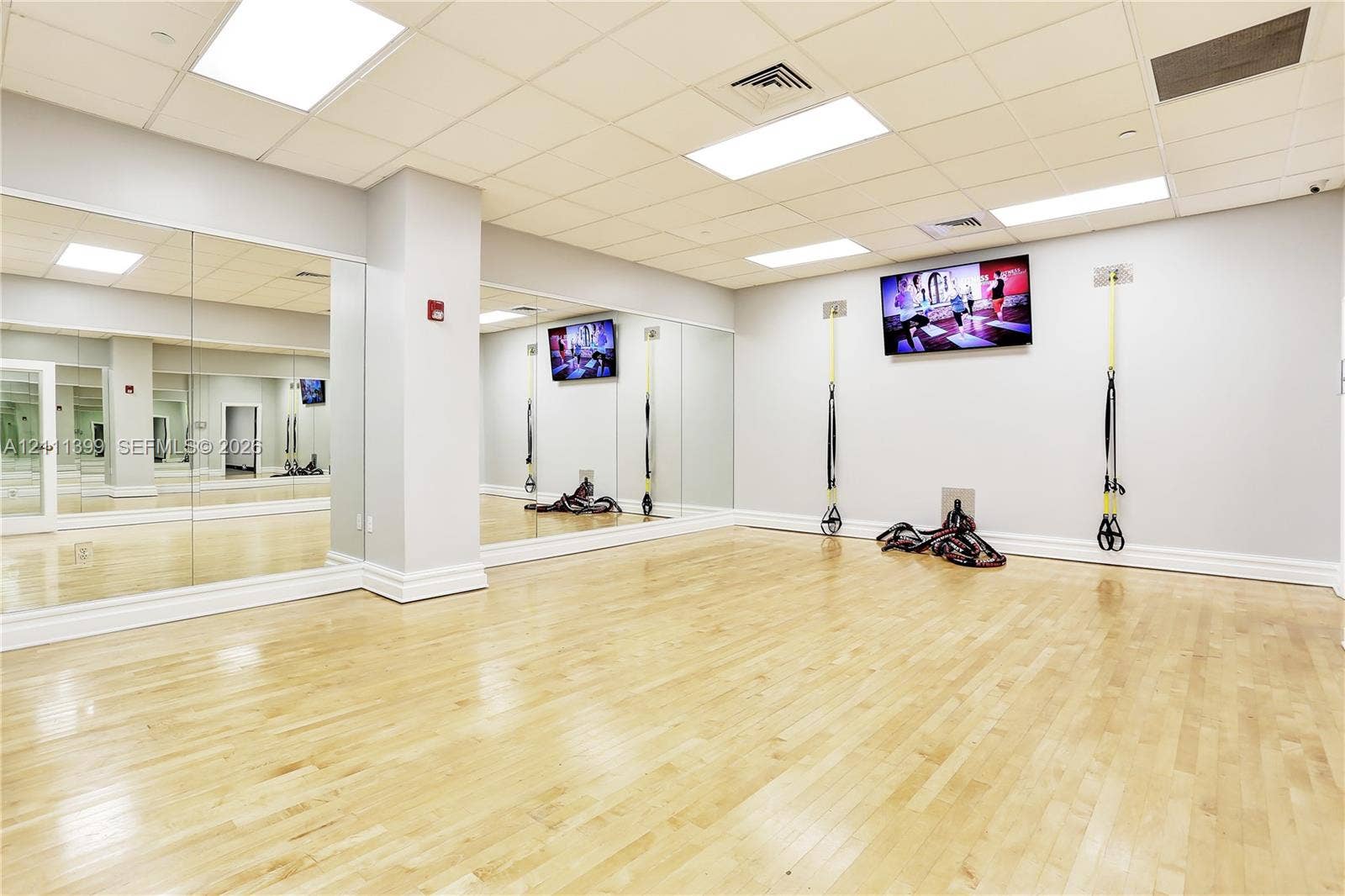 2501 S Ocean Drive, #1630, Hollywood, Hollywood, FL 33019 Fitness area featuring wood-finish flooring, full-length wall mirrors, recessed panel lighting, and wall-mounted television screens