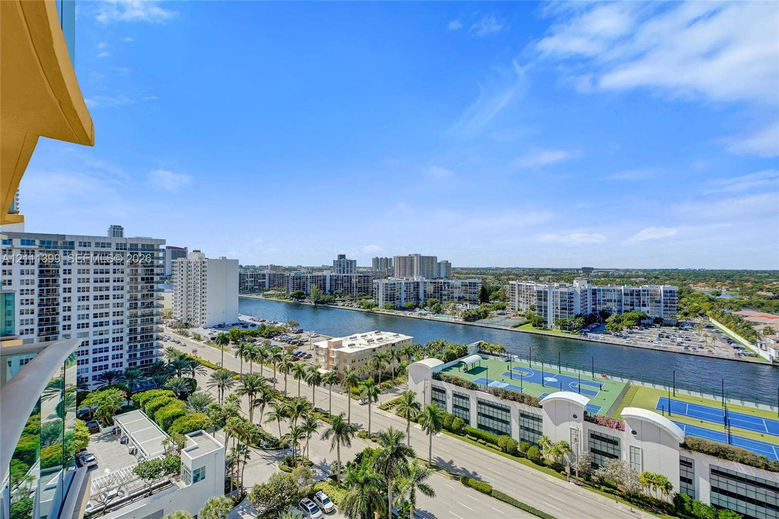 2501 S Ocean Drive, #1630, Hollywood, Hollywood, FL 33019 Elevated balcony perspective overlooking a waterway, paved streets, palm-lined grounds, and recreational courts