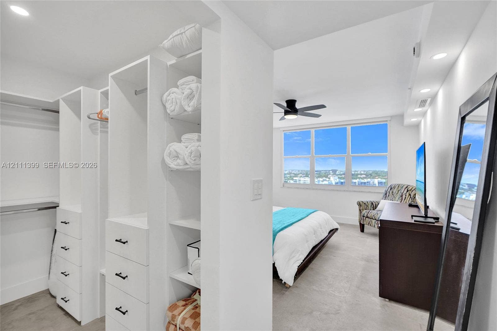 2501 S Ocean Drive, #1630, Hollywood, Hollywood, FL 33019 Custom walk-in closet featuring white built-in shelving, hanging rods, and drawers with matte black hardware, recessed ceiling lighting, and large windows with exterior scenery