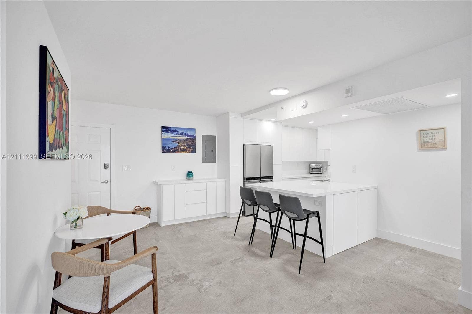2501 S Ocean Drive, #1630, Hollywood, Hollywood, FL 33019 Modern kitchen featuring a central island with integrated storage, flat-panel cabinetry, light-toned stone-finish countertops, stainless steel appliances, and large-format tile flooring