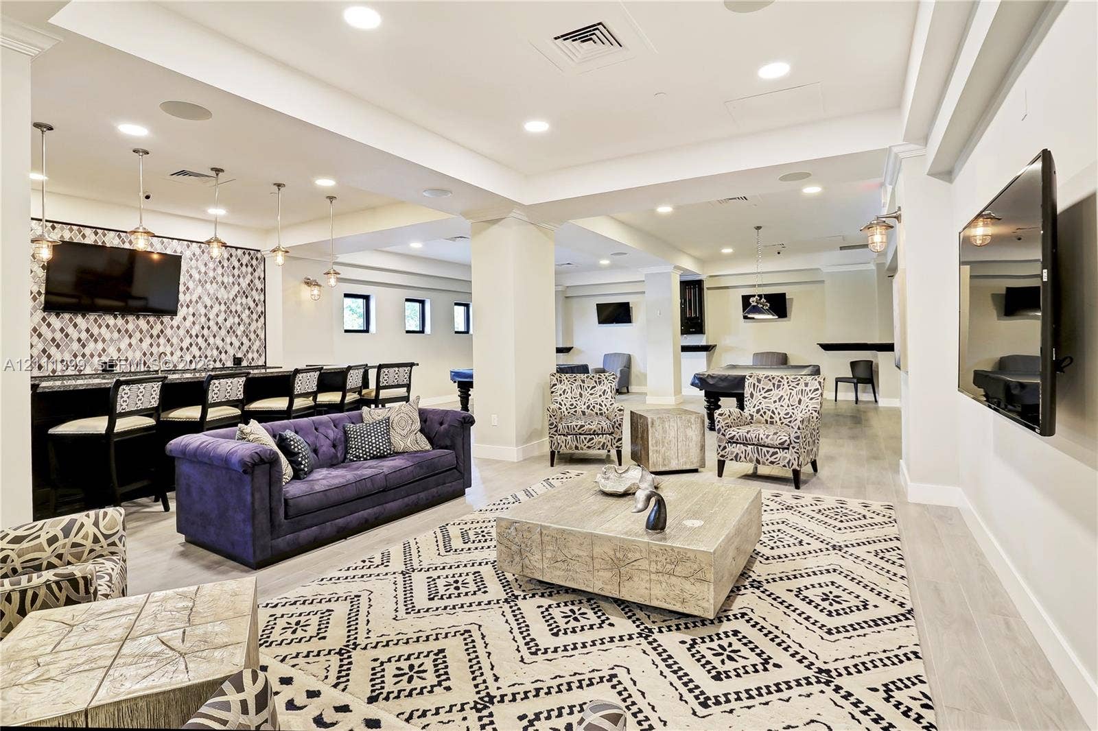 2501 S Ocean Drive, #1630, Hollywood, Hollywood, FL 33019 Open-concept common area featuring recessed lighting, light-toned wood-finish flooring, a full wet bar with patterned tile backsplash, and multiple mounted television screens
