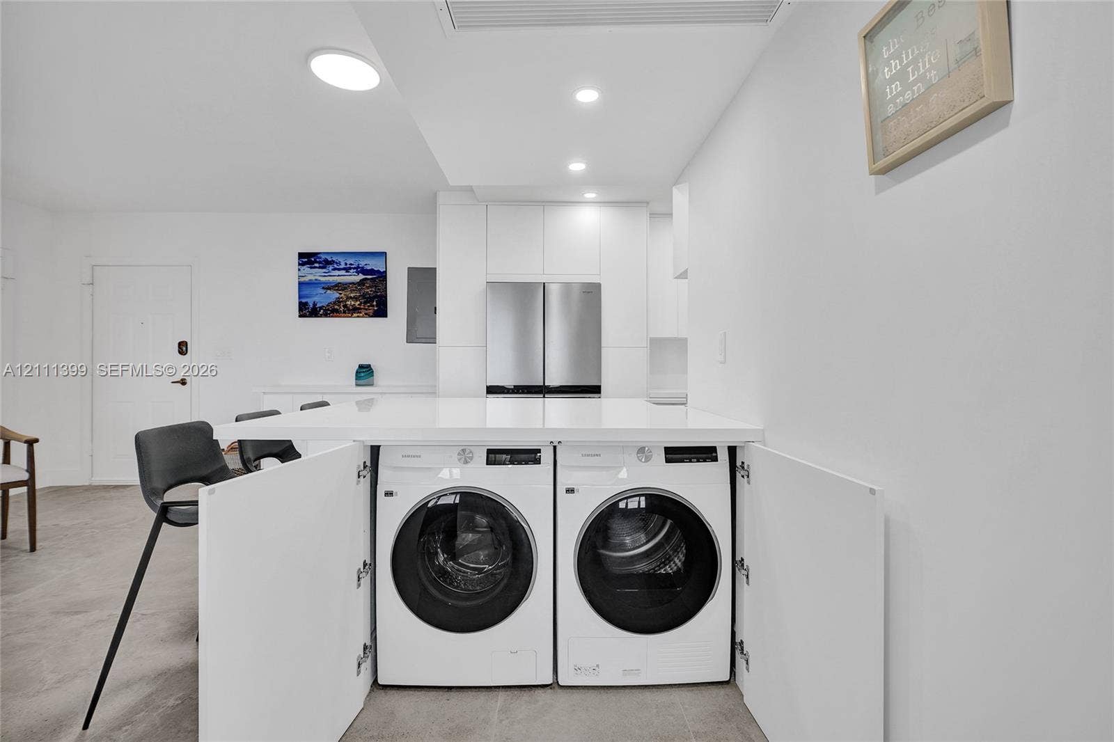 2501 S Ocean Drive, #1630, Hollywood, Hollywood, FL 33019 Kitchen featuring white flat-panel cabinetry, stainless steel appliances, solid-surface countertop, and integrated laundry center with built-in cabinetry