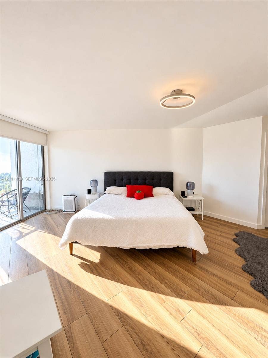 1700 N River Drive, #1004, Miami, FL 33125 Wood-finish flooring, sliding glass door, and circular LED ceiling light fixture