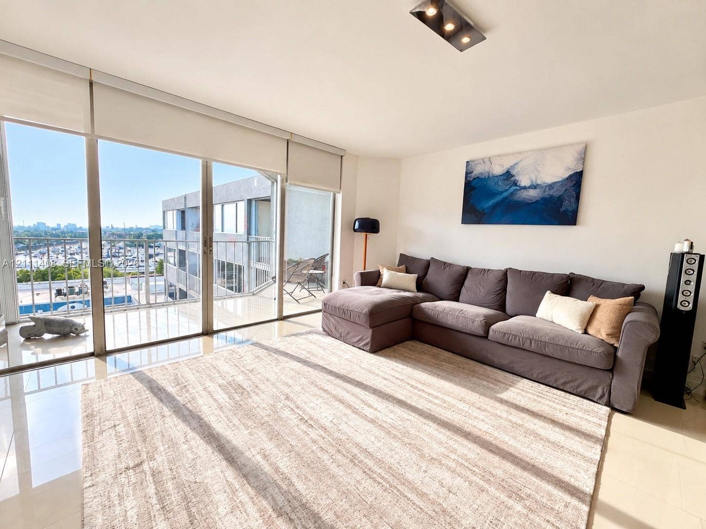 1700 N River Drive, #1004, Miami, FL 33125 Open-concept living space featuring floor-to-ceiling glass sliding doors, polished tile flooring, and dual modern rectangular flush-mount ceiling light fixtures