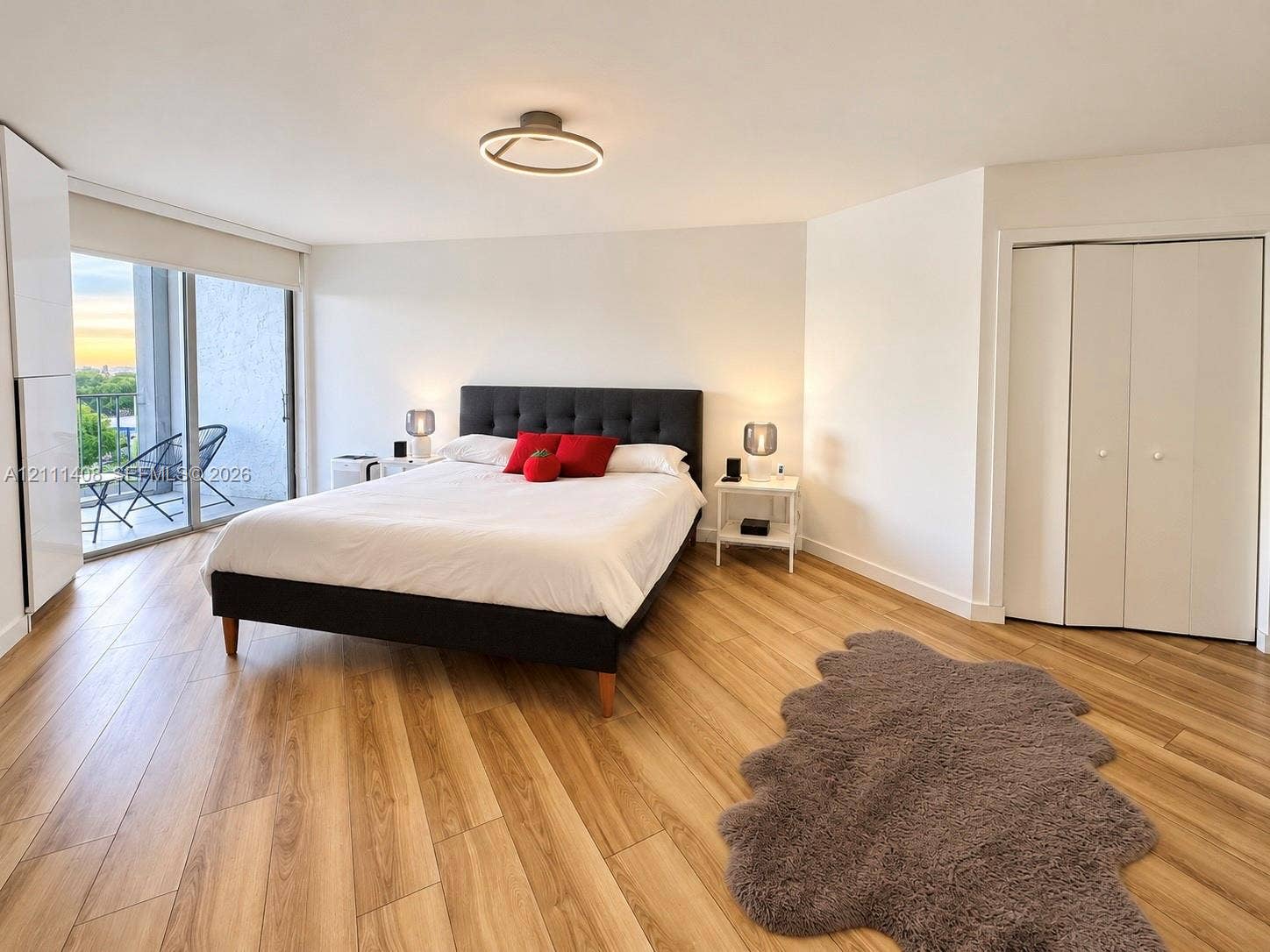 1700 N River Drive, #1004, Miami, FL 33125 Wood-finish flooring, flush-mount circular lighting, and sliding glass doors leading to a balcony