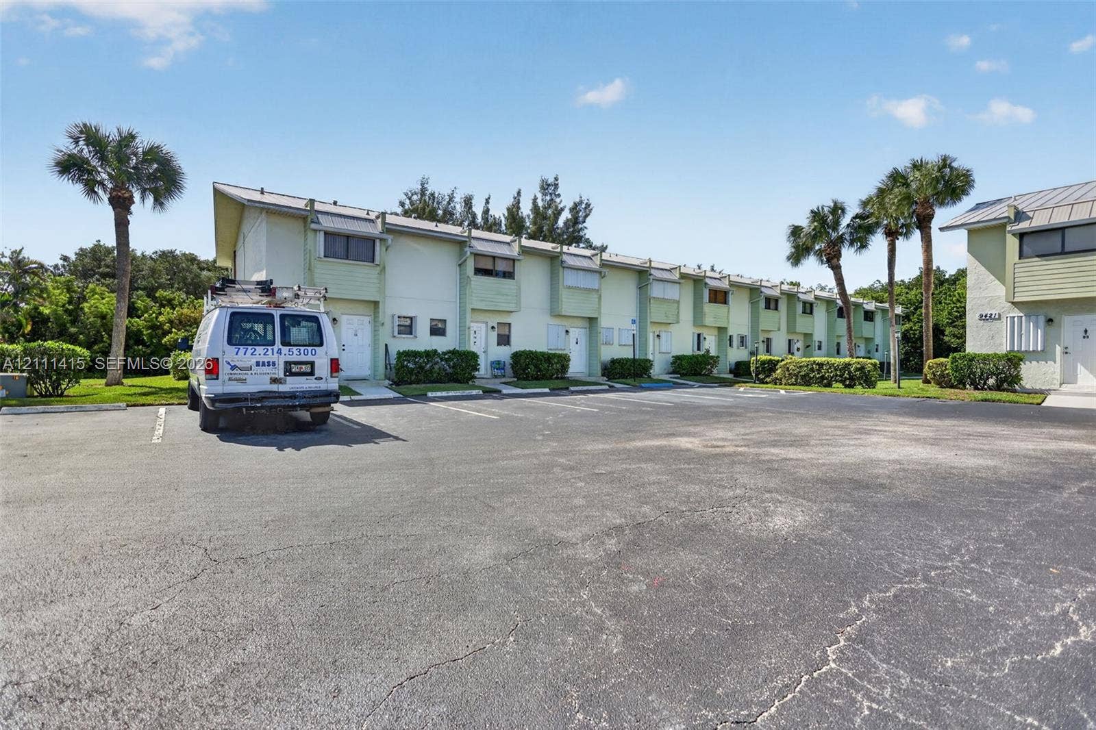 9423 S Ocean Drive, #80, Jensen Beach, FL 34957 Multi-unit residential complex featuring light-toned siding, metal roofing, individual entryways, and palm tree landscaping