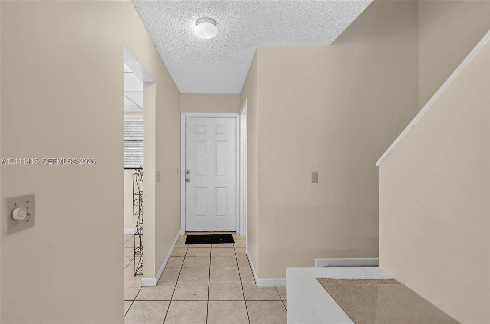 9423 S Ocean Drive, #80, Jensen Beach, FL 34957 Entry area featuring tile flooring, six-panel door, and flush-mount lighting