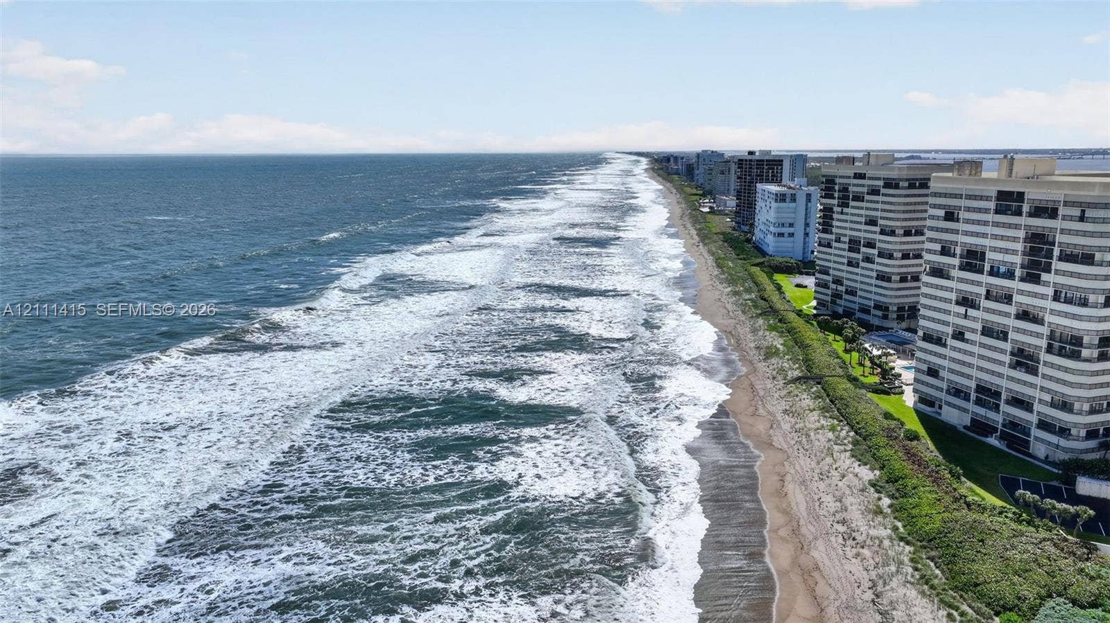 9423 S Ocean Drive, #80, Jensen Beach, FL 34957 Direct oceanfront positioning featuring a sandy beach, expansive coastline, and multi-story structural architecture