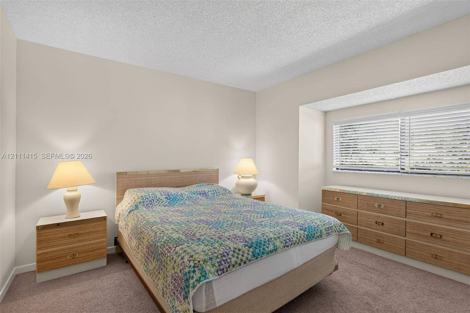 9423 S Ocean Drive, #80, Jensen Beach, FL 34957 Bedroom featuring neutral wall paint, carpeted flooring, a recessed window nook, and built-in wood-finish cabinetry