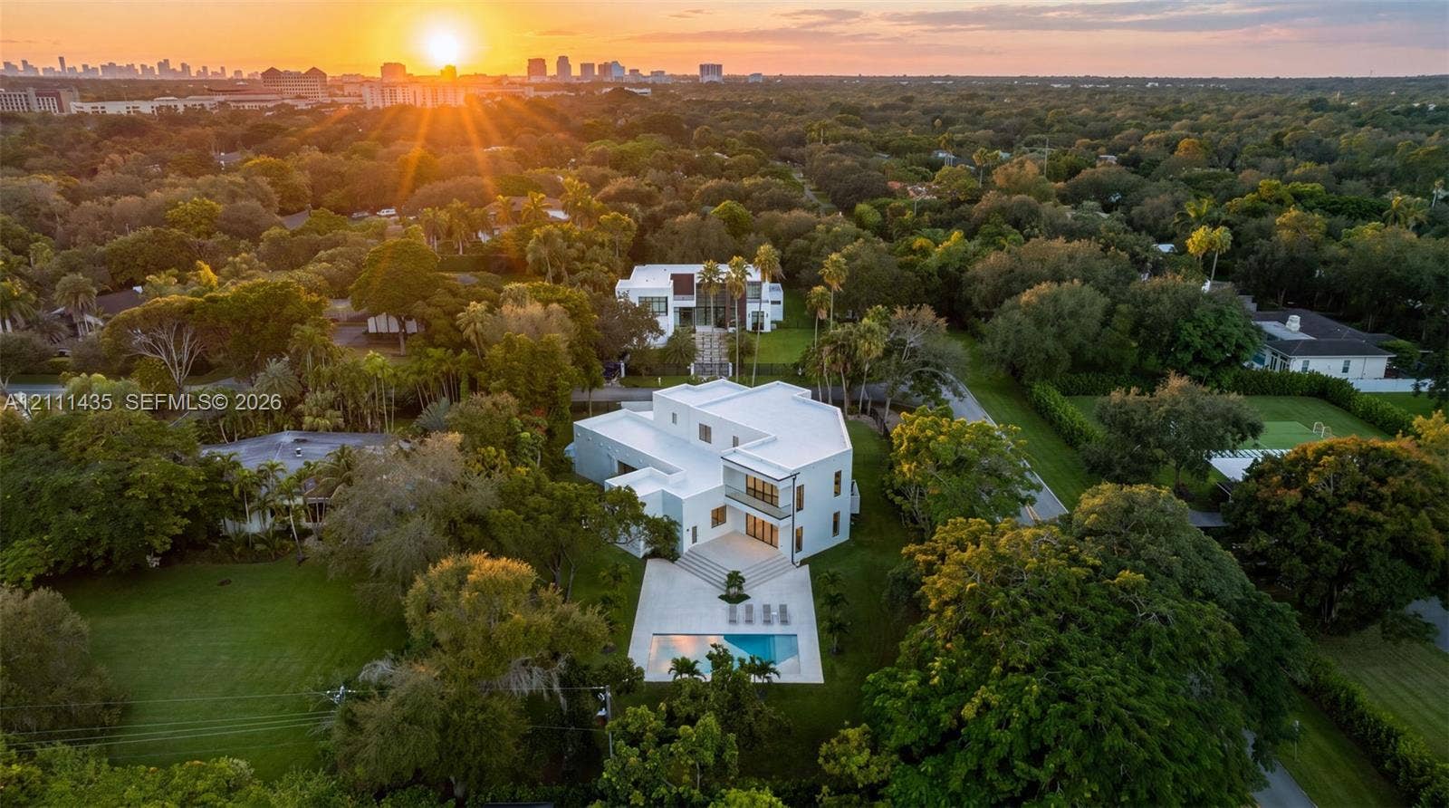 9530 SW 95th Court, Miami, FL 33176 Modern architectural estate featuring a flat roofline, multi-level exterior, rear swimming pool, concrete patio, and landscaped grounds