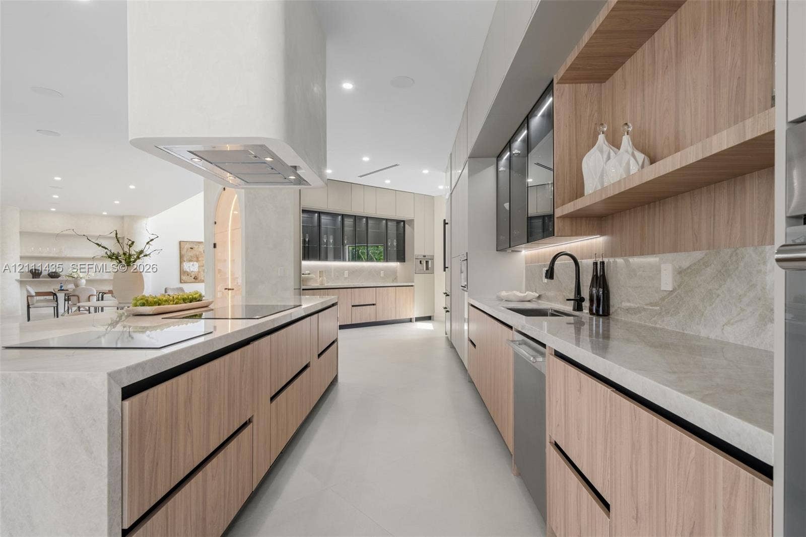 9530 SW 95th Court, Miami, FL 33176 Modern kitchen featuring wood-finish cabinetry, stone countertops, integrated ceiling lighting, a matte black faucet, and a custom range hood