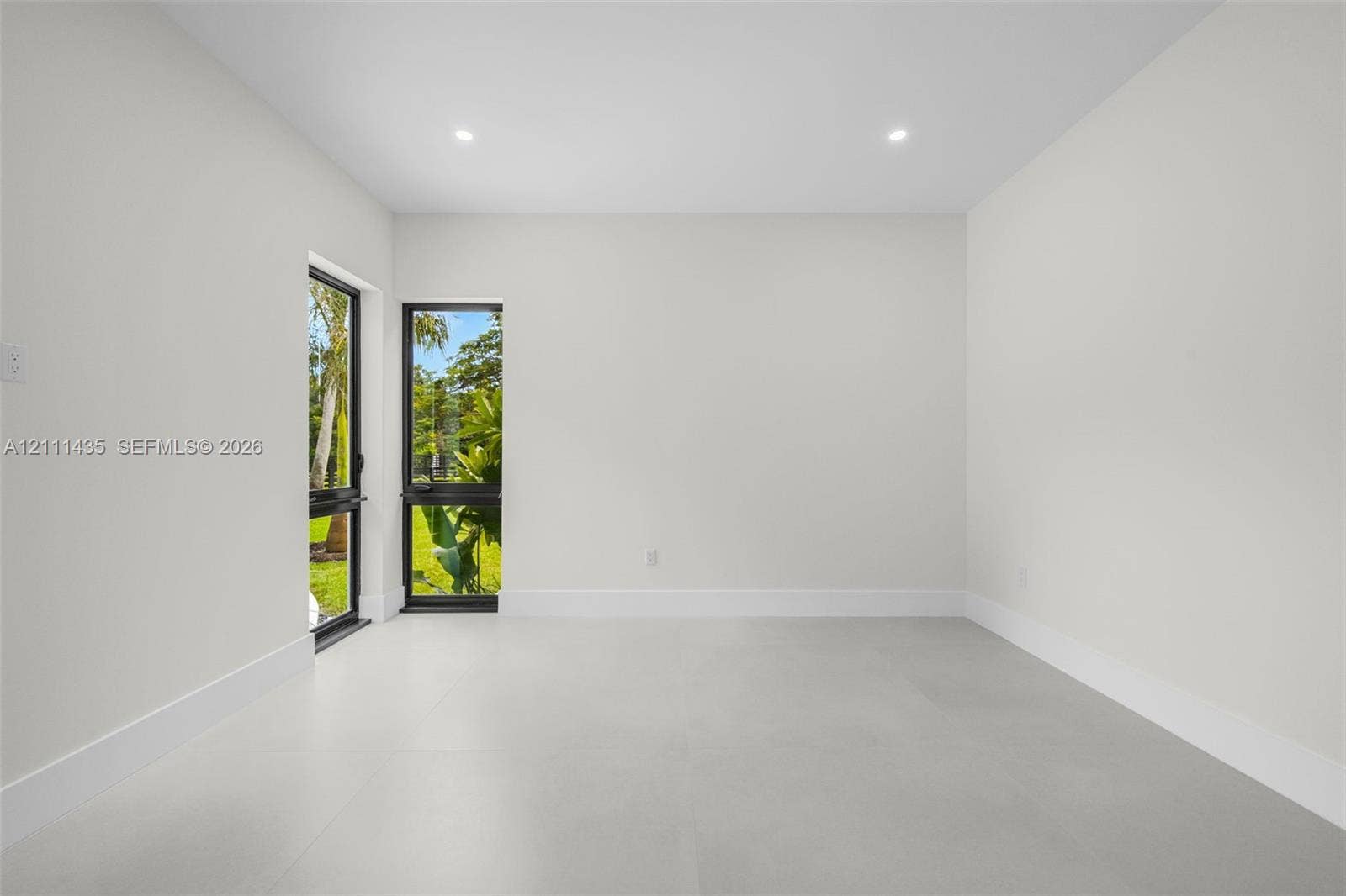 9530 SW 95th Court, Miami, FL 33176 Interior space featuring large-format neutral tile flooring, recessed ceiling lighting, and black-framed glass exterior doors