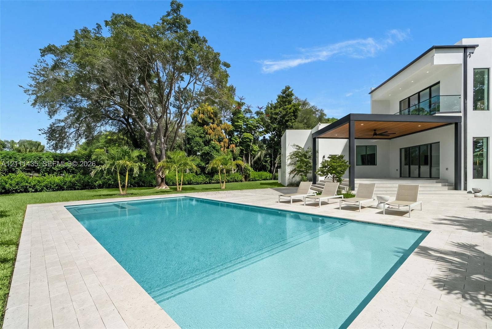9530 SW 95th Court, Miami, FL 33176 Modern exterior featuring a swimming pool, integrated spa, stone-paver decking, and a covered lanai with a wood-finished ceiling