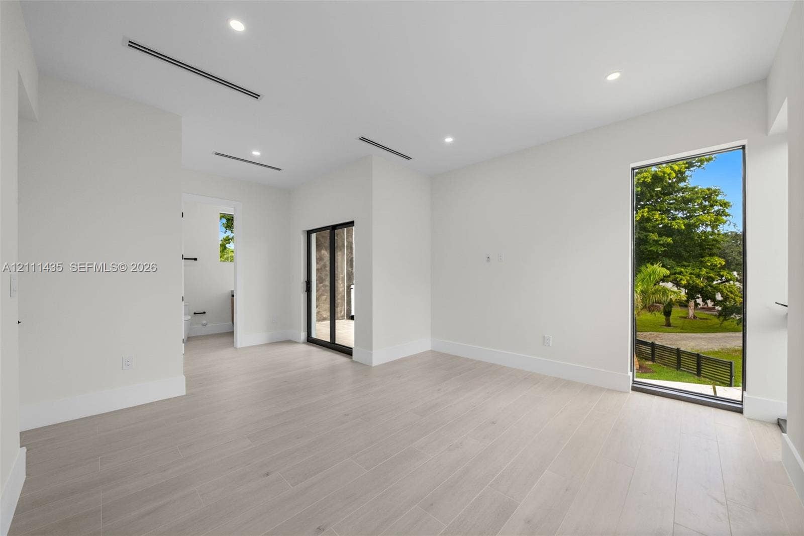 9530 SW 95th Court, Miami, FL 33176 Neutral-toned wood-finish flooring, recessed lighting, floor-to-ceiling window, and sliding glass door