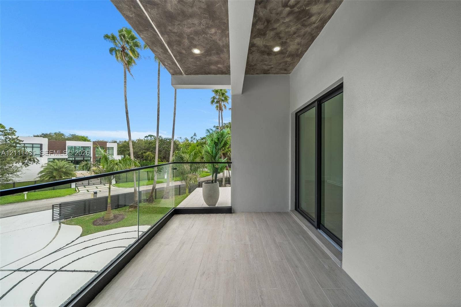 9530 SW 95th Court, Miami, FL 33176 Covered balcony featuring wood-finish flooring, recessed lighting, concrete-texture ceiling finish, and a glass panel railing