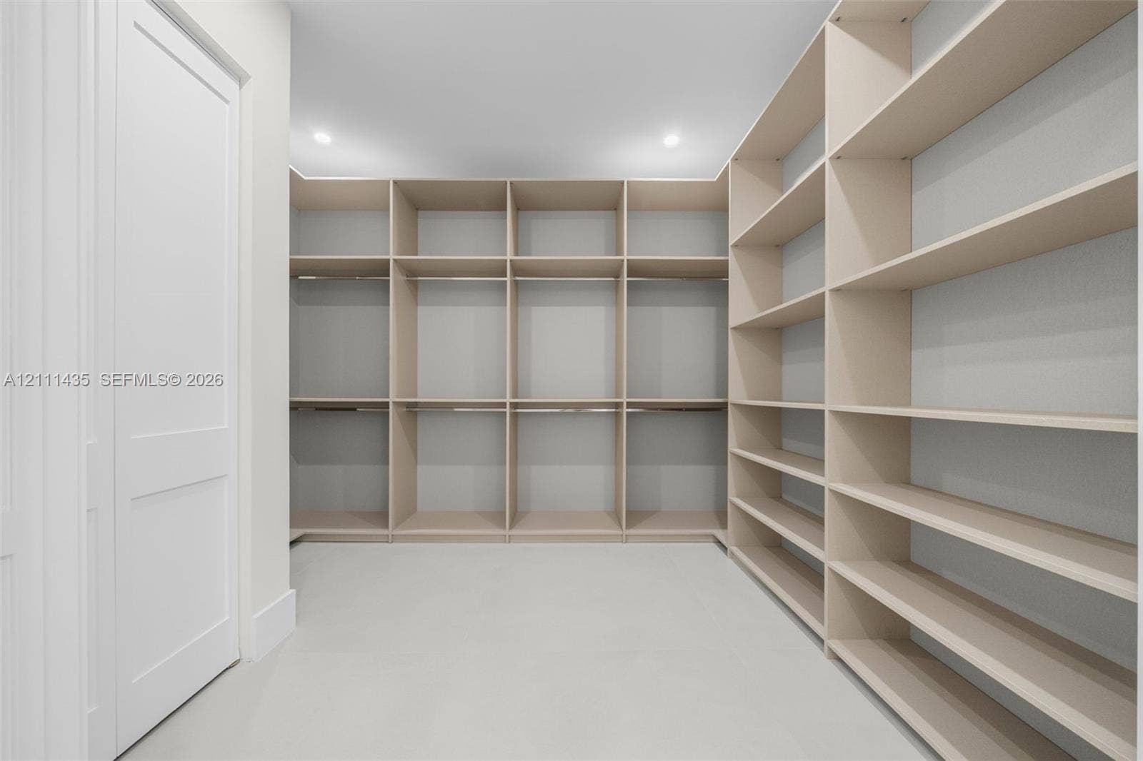 9530 SW 95th Court, Miami, FL 33176 Custom walk-in storage area featuring extensive built-in shelving, integrated hanging rods, crisp white walls, and recessed lighting