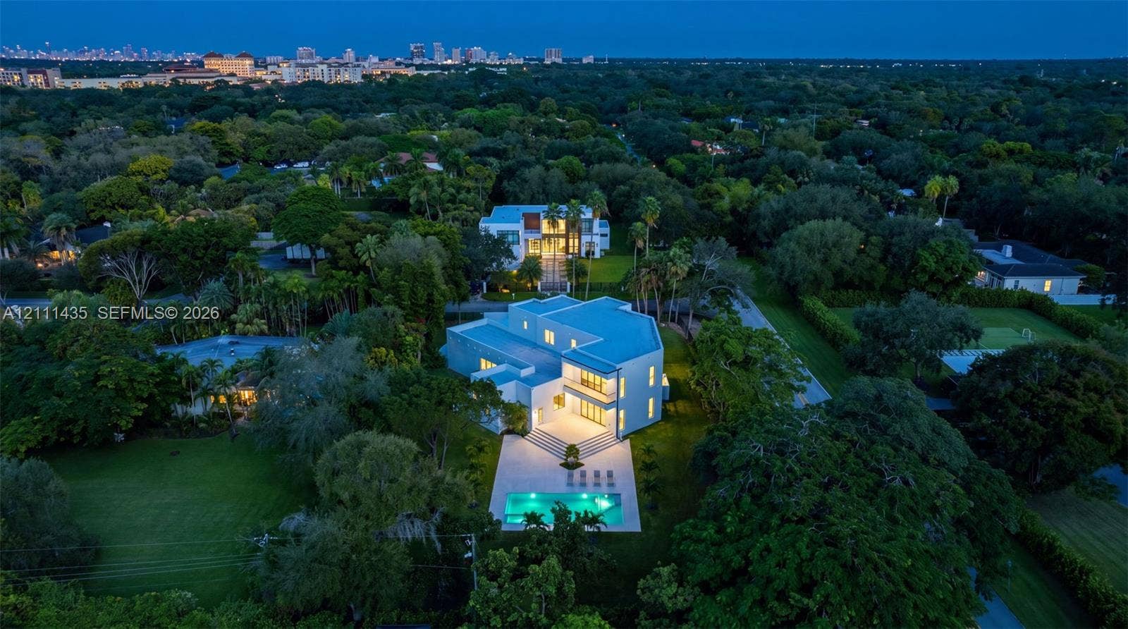 9530 SW 95th Court, Miami, FL 33176 Aerial perspective featuring a multi-level contemporary residence, expansive manicured grounds, a rectangular swimming pool, and mature foliage