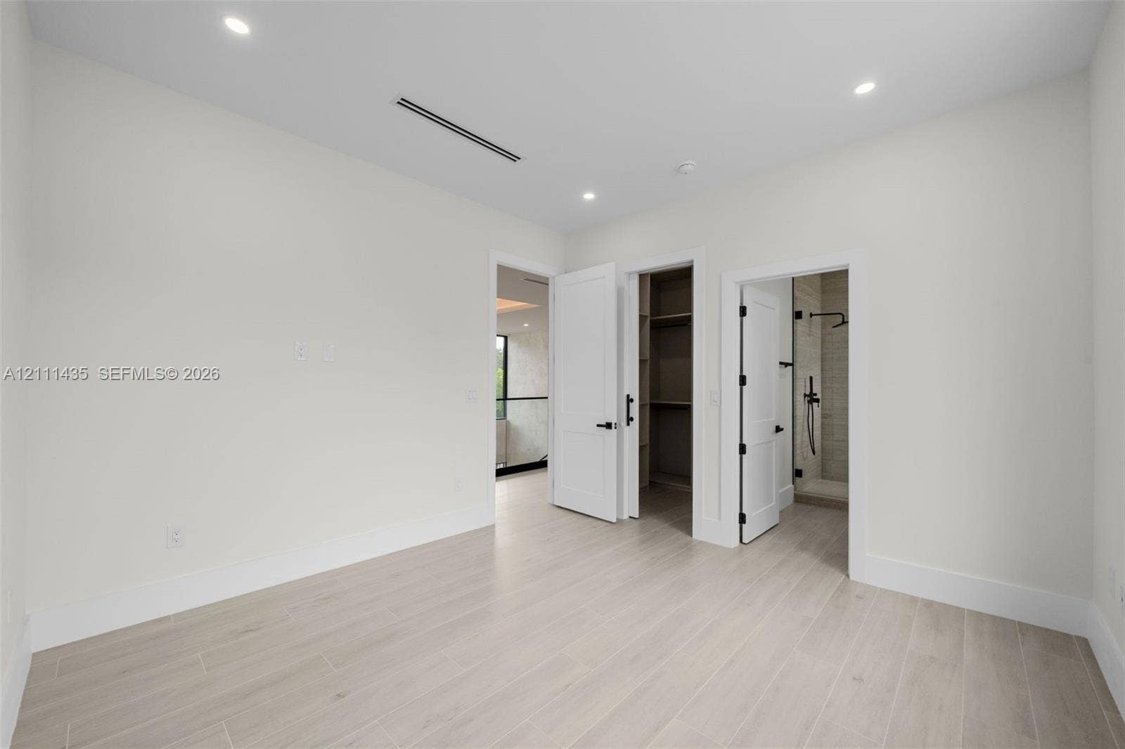 9530 SW 95th Court, Miami, FL 33176 Neutral room with wood-finish flooring, recessed lighting, built-in closet shelving, and shaker-style interior doors