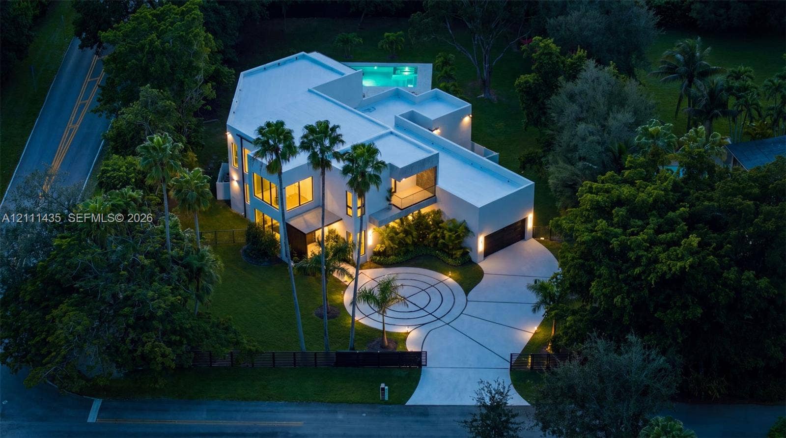 9530 SW 95th Court, Miami, FL 33176 Contemporary multi-level residence featuring a flat roofline, circular decorative concrete driveway, attached multi-car garage, and an elevated swimming pool