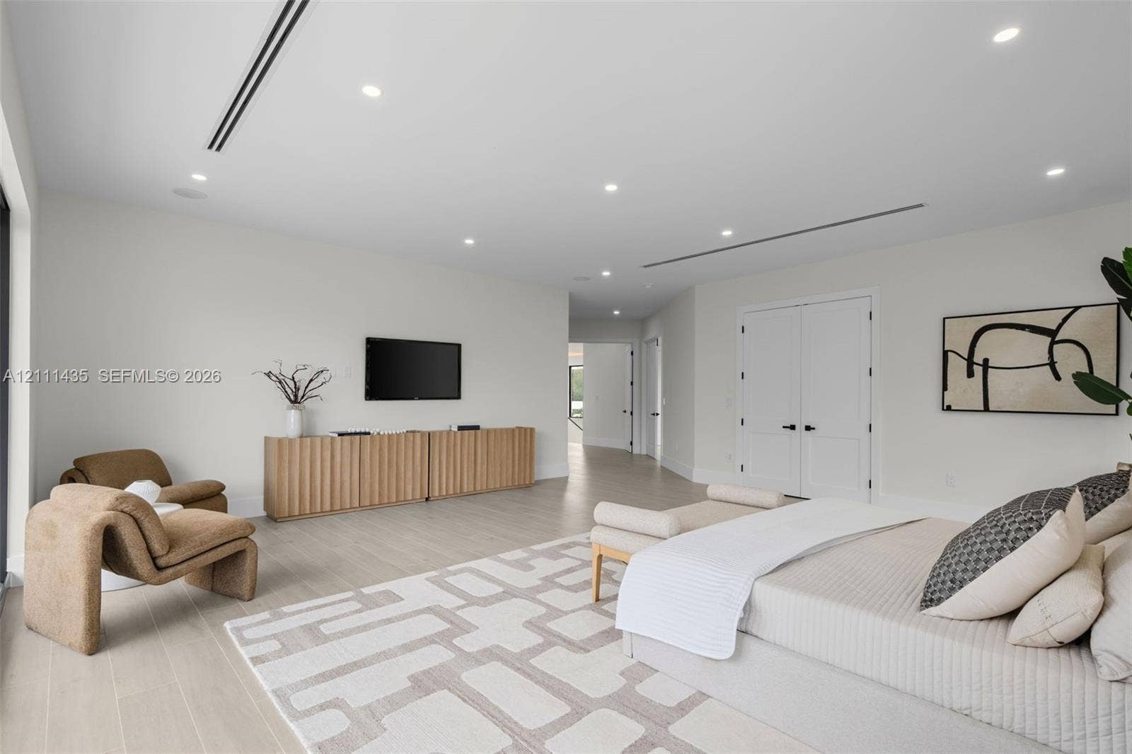 9530 SW 95th Court, Miami, FL 33176 Neutral-toned interior featuring wood-finish flooring, recessed LED lighting, integrated linear air vents, and double-panel doors with matte black hardware