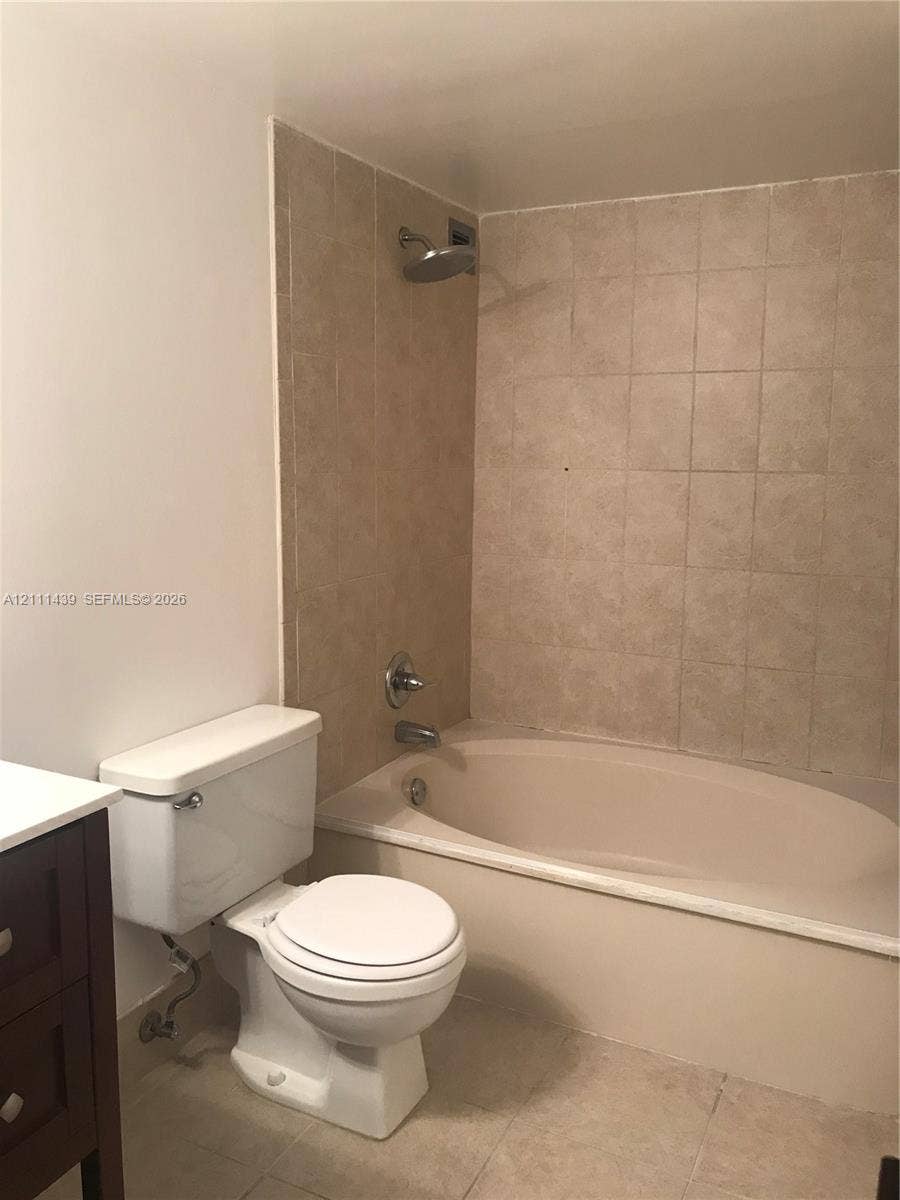 800 Parkview Drive, #102, Hallandale Beach, Hallandale Beach, FL 33009 Bathroom featuring a soaking tub, wall-mounted shower head, ceramic tile surround, and neutral floor tile
