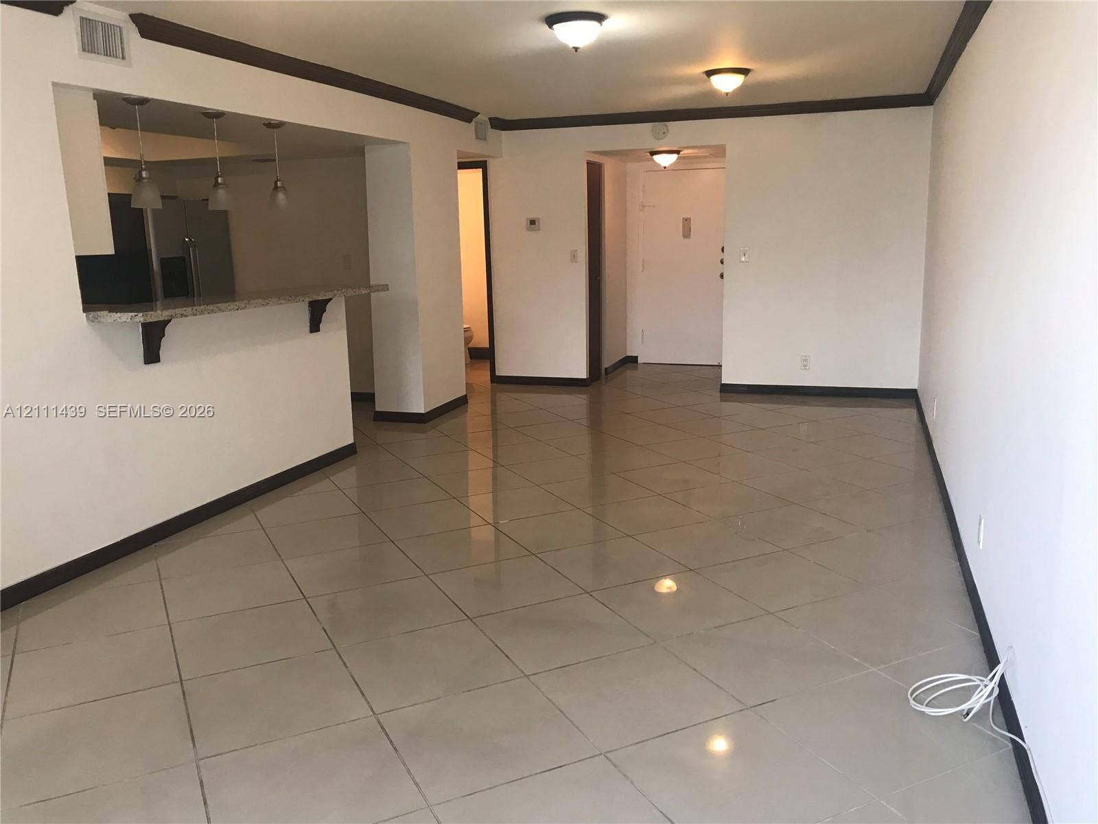 800 Parkview Drive, #102, Hallandale Beach, Hallandale Beach, FL 33009 Open-concept interior featuring large-format tile flooring, a stone-surfaced breakfast bar, and three pendant light fixtures