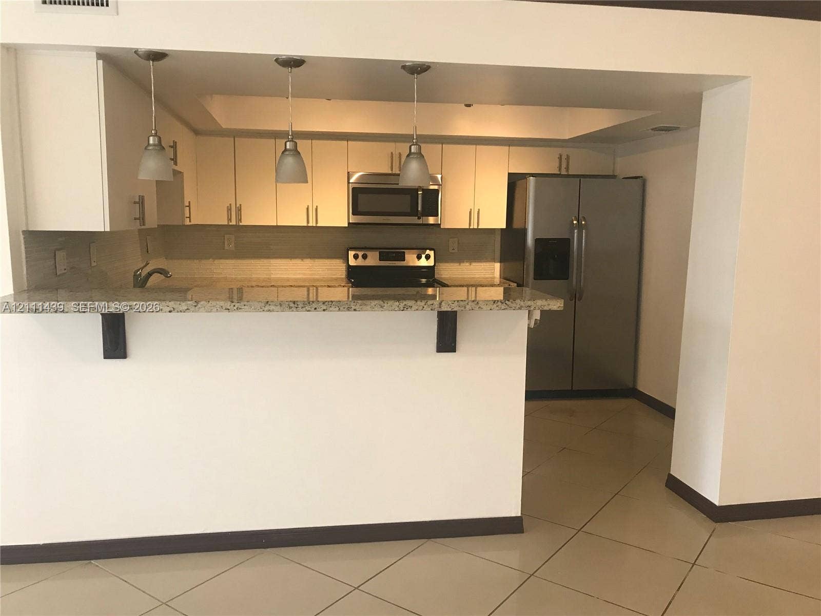 800 Parkview Drive, #102, Hallandale Beach, Hallandale Beach, FL 33009 Kitchen featuring white cabinetry, stone-finish countertops, stainless steel appliances, and pendant lighting