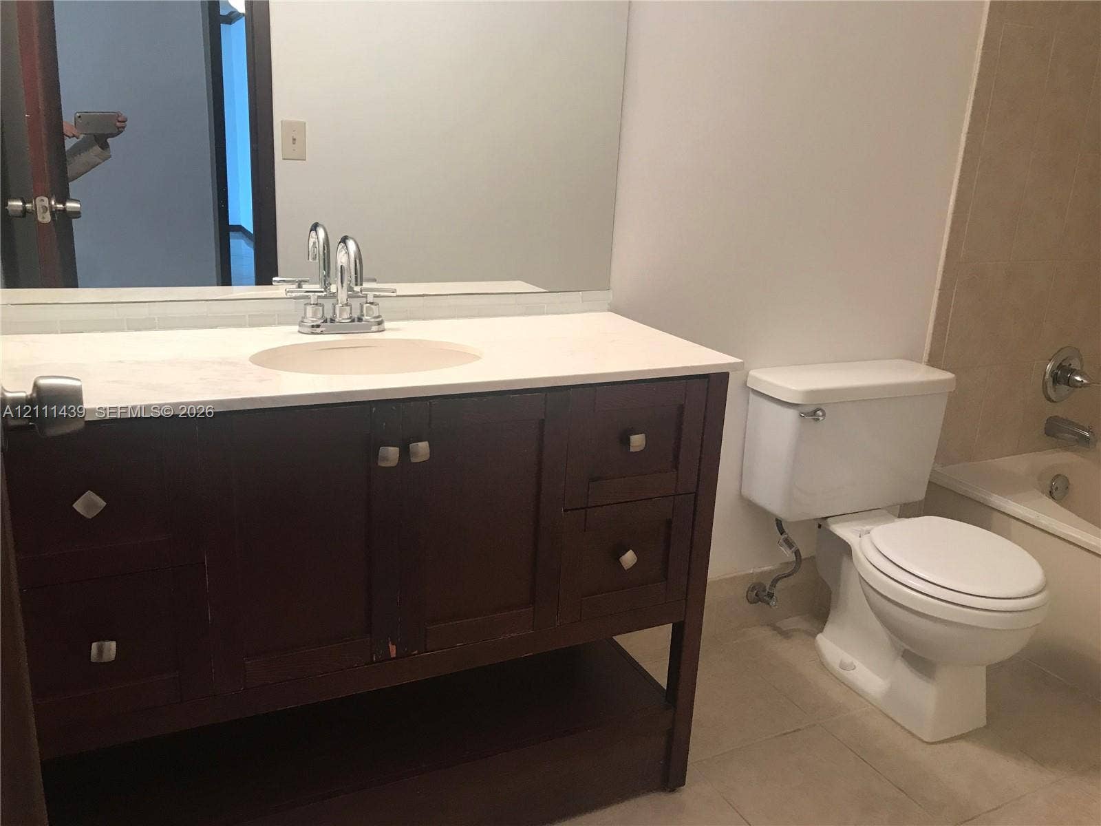800 Parkview Drive, #102, Hallandale Beach, Hallandale Beach, FL 33009 Dark wood vanity with a solid surface countertop, integrated sink basin, polished chrome faucet, and large rectangular wall-mounted mirror
