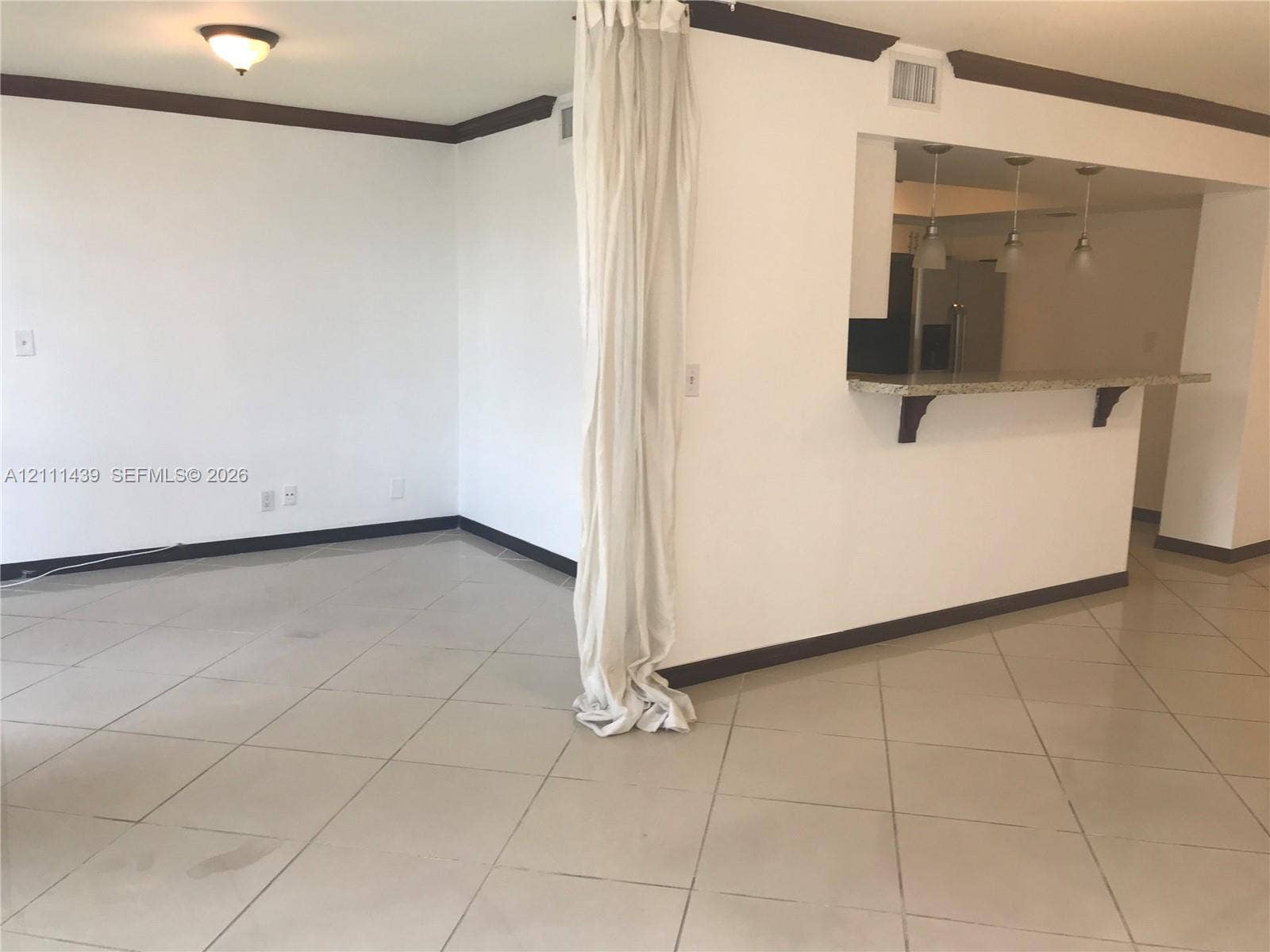 800 Parkview Drive, #102, Hallandale Beach, Hallandale Beach, FL 33009 Neutral-toned floor tiling, breakfast bar with stone-finish countertop, three pendant lights, and dark wood-tone crown molding