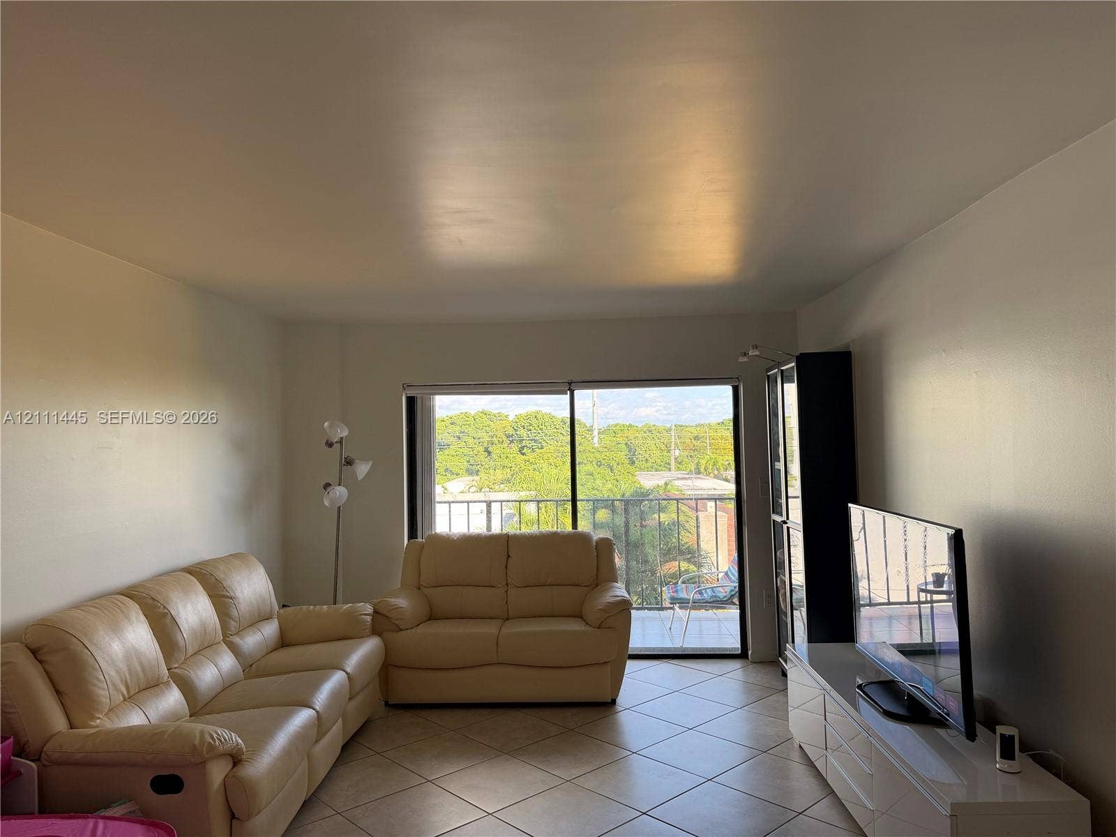 8255 Abbott Avenue, #402, Miami Beach, Miami Beach, FL 33141 Living area featuring large format diagonal tile flooring and sliding glass doors opening to a balcony