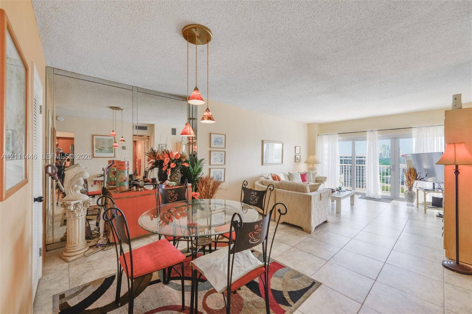 1965 S Ocean Drive, #15M, Hallandale Beach, Hallandale Beach, FL 33009 Ceramic tile flooring, full-length wall mirrors, three-light hanging pendant fixture, and sliding glass doors with balcony access