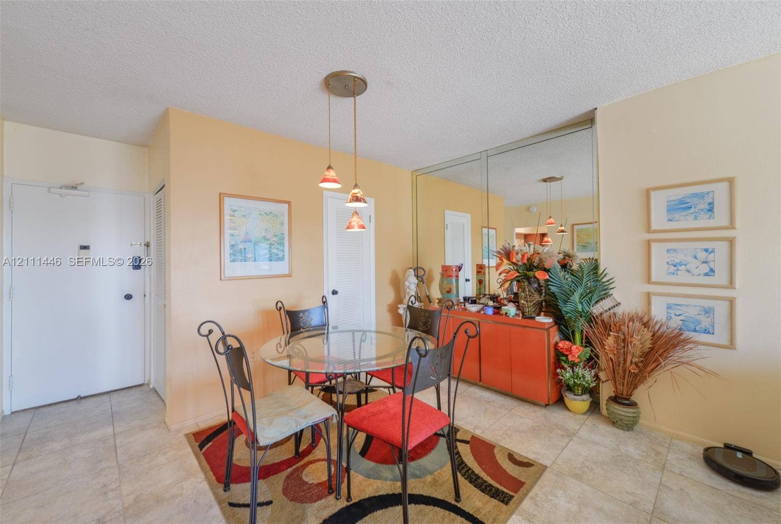 1965 S Ocean Drive, #15M, Hallandale Beach, Hallandale Beach, FL 33009 Neutral-toned tile flooring, tri-pendant lighting fixture, and floor-to-ceiling mirrored wall paneling